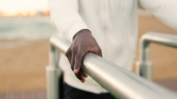 istock Close-up of male hands doing triceps dips on parallel bars outdoors, sports motivation, active lifestyle 2171031484