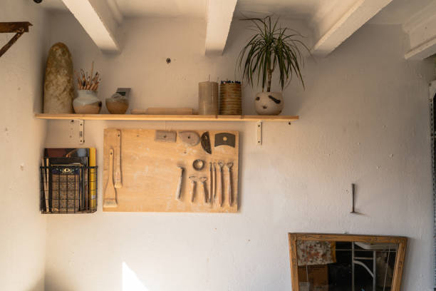 istock A cozy artisan's corner with a variety of pottery tools lined up on a pegboard, ceramic works on a shelf, and a refreshing plant adding a touch of greenery 2171032270