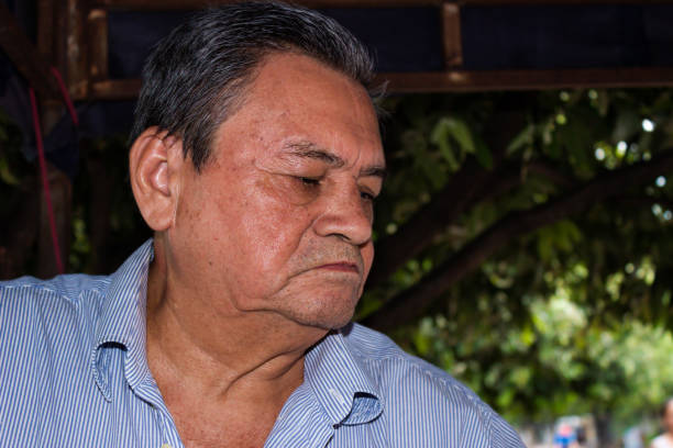 Elderly Latino man looking down