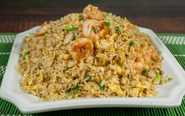 Shrimp biryani on white plate and on marble bistro table. Directly above.
