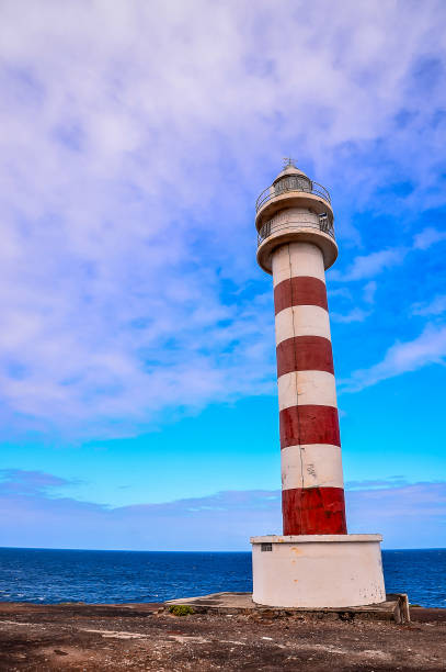 istock A lighthouse is standing on a rocky shoreline, overlooking the ocean 2171041135