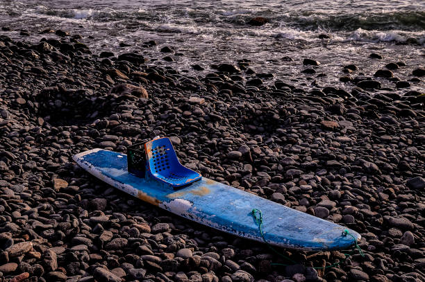 Close up shot of upside down surfboards on a car roof, mountains and sky behind. Taken in Kauai, Hawaii, during the day.