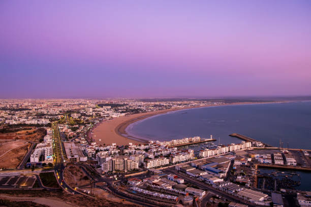 Agadir, Morocco at sunset. Panoramic view of Agadir city and bay in southern Morocco with Marina, beach and ocean from Oufla or Casbah fortress. Moroccan seaside resort on Atlantic coast in Africa Agadir, Morocco at sunset. Panoramic view of Agadir city and bay in southern Morocco with Marina, beach and ocean from Oufla or Casbah fortress. Moroccan seaside resort on Atlantic coast in Africa. sunset agadir marocco stock pictures, royalty-free photos & images