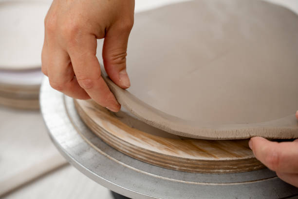 istock Using a sharp pottery carving knife to cut out a perfect round shape from clay. Ceramics class. Modeling clay into a round form. 2171045233