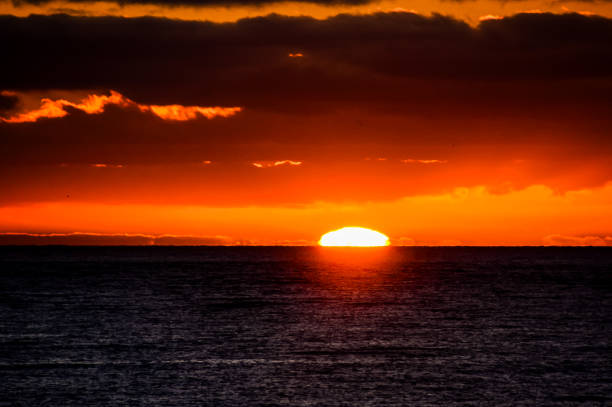 istock The sun is setting over the ocean, creating a beautiful and serene atmosphere 2171046277