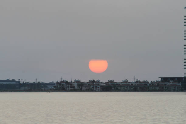 A mesmerizing sunset casts vibrant hues across the horizon, blending with textured clouds to create a dramatic and serene landscape.