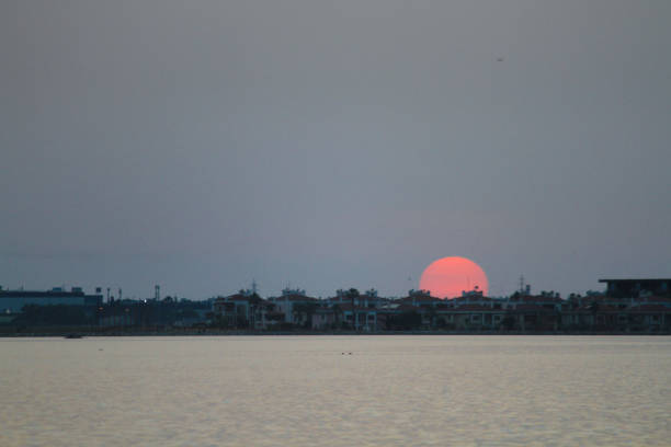 A mesmerizing sunset casts vibrant hues across the horizon, blending with textured clouds to create a dramatic and serene landscape.