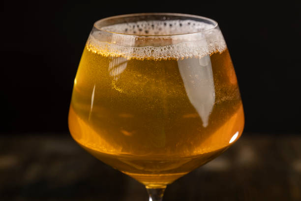 pour apple juice into a glass, yellow apple juice in a clear glass with bubbles