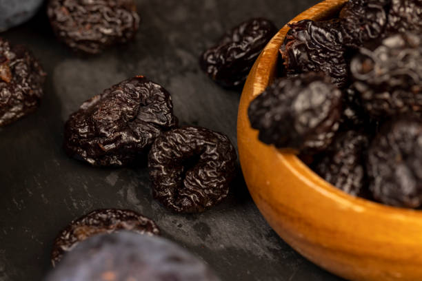istock ripe purple plums and dried plums 2171048359