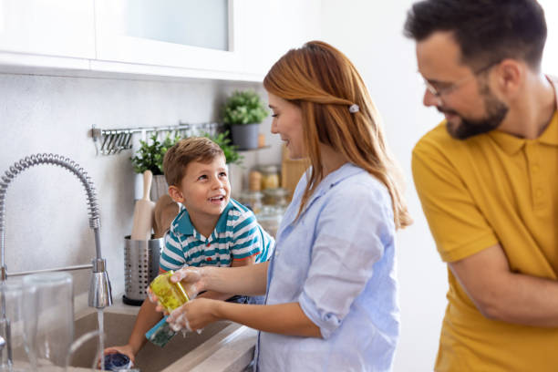 istock Family washing dishes together in modern kitchen space 2171050741