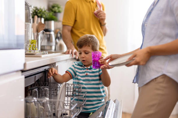 istock Family helping young boy load dishwasher in kitchen 2171050755