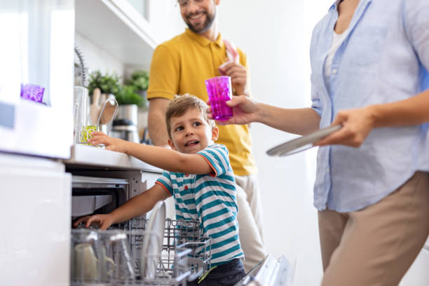 istock Family teamwork loading the dishwasher in modern kitchen 2171050784