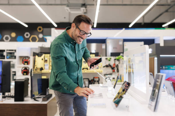 istock Man comparing the latest smart phones in a modern electronics store 2171051948