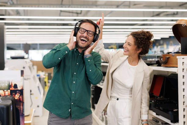 istock Joyful couple dancing while listening to vinyl in a tech-infused record store 2171052002