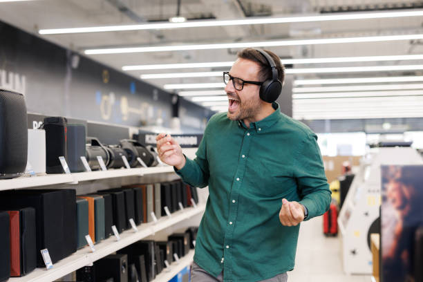 istock Man dancing  with wireless headphones in a music store 2171052004
