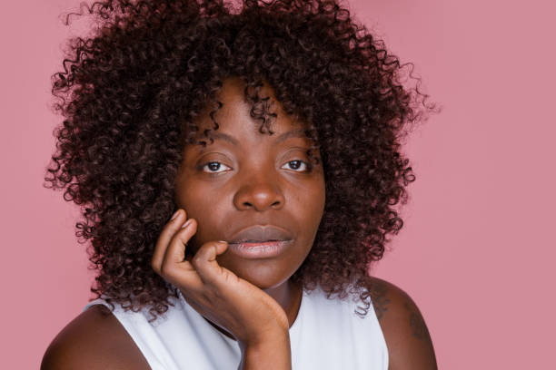 istock woman with afro hairstyle posing in studio with pink background 2171053847