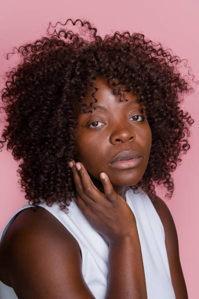 istock woman touching her face on pink background 2171053854