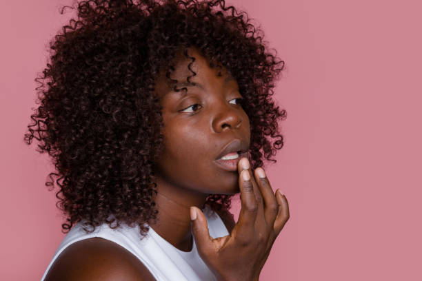 istock woman applying lip balm on pink background 2171053888