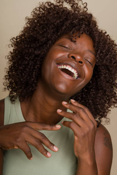 istock Woman with curly hair throwing her head back in laughter 2171054285