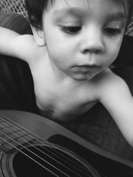 Baby touches guitar as father plays