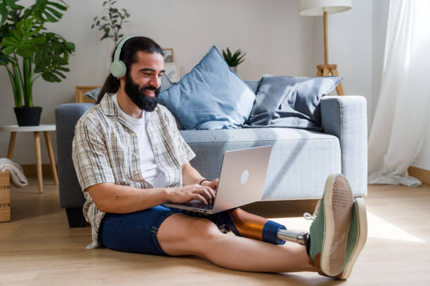 istock Young freelancer with disability using laptop and headphones at home 2171055904