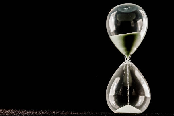 istock A glass hourglass with sand in it is on a black background 2171055992