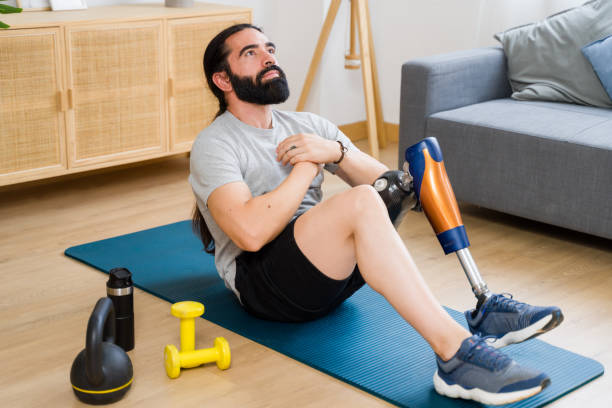 istock Young man with prosthetic leg doing sit ups at home 2171056235