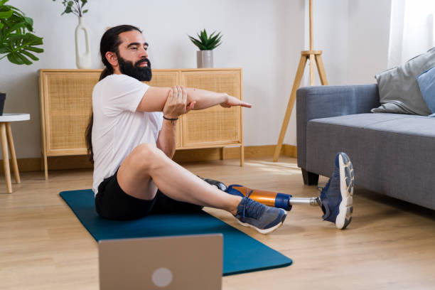istock Young man with prosthetic leg doing stretching exercises at home 2171056352