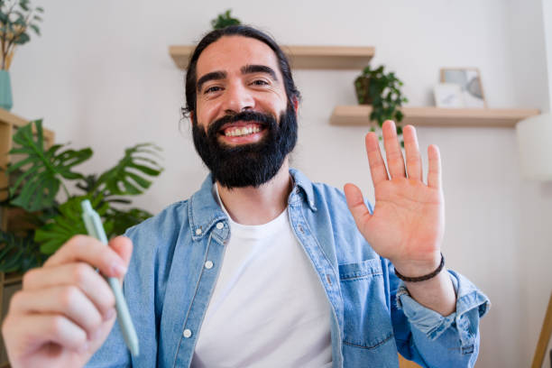 istock Happy freelancer waving during a video call at home office 2171056691