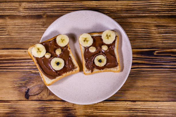 Two sandwiches with chocolate spread on a plate. Sandwich like a bear muzzle. Top view