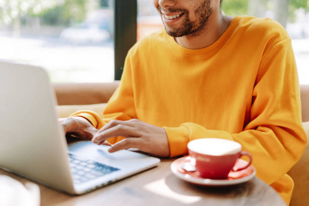 istock Smiling freelancer, young businessman working on laptop in cafe with coffee, selective focus 2171063748