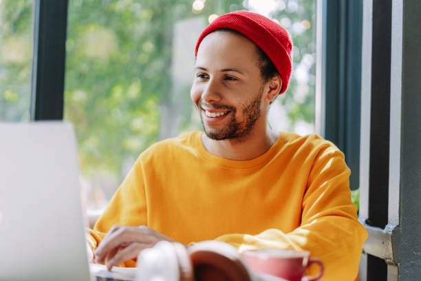 istock Freelancer professional programmer smiling and working on laptop in cafe, stylish hipster in red hat 2171063755