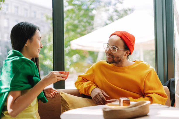 istock Young multiracial, smiling couple enjoying coffee and conversation in a cafe 2171063769
