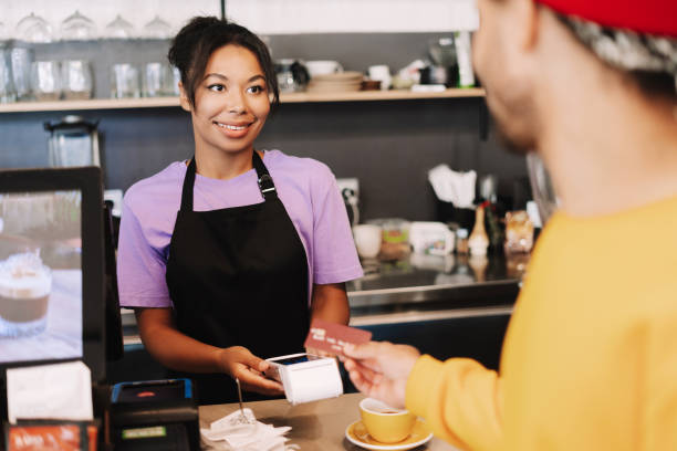 istock Smiling barista accepting credit card payment from customer 2171064894