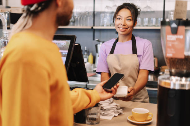 istock Customer making a contactless payment with smartphone in a coffee shop 2171064939