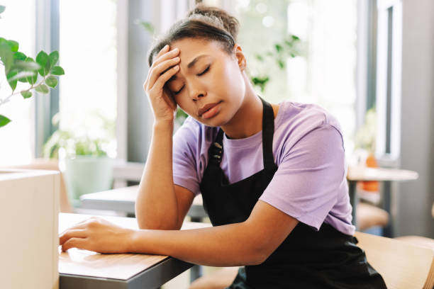 istock Tired african american waitress suffering headache sitting at table in cafe 2171064971