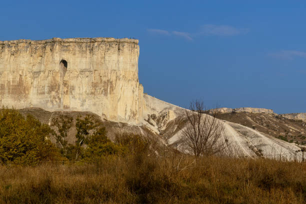 istock White rock. Flat white Mountain with sheer cliff in middle of plain. 2171068304
