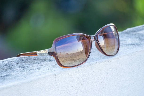 istock Eyewear resting on a wall outdoors, reflecting the beautiful sky inside the glass. 2171070299