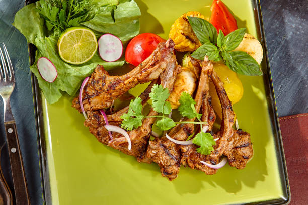 istock Grilled Lamb Chops with Fresh Vegetables on Green Plate 2171071694