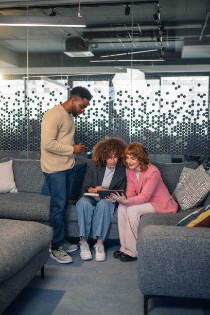 istock Interracial group of young businesspeople at office lobby using tablet 2171077045