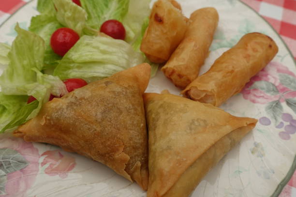istock Samosas and Spring Rolls served with seasoned green salad and cherry tomatoes 2171084530