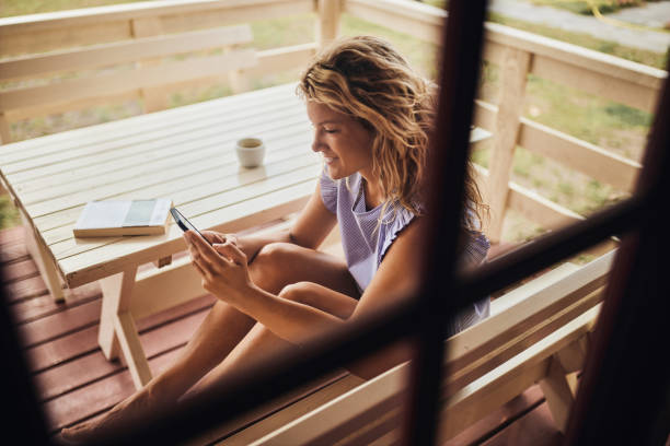 istock Happy woman using mobile phone on a patio. 2171091558