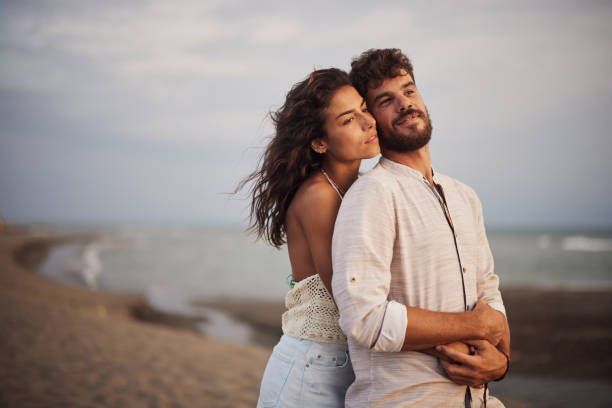 istock Young couple in love standing embraced on the beach. 2171091702
