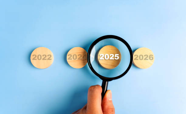 istock Man hand using magnifying glass focusing on word 2025 New Year concept. 2171094131