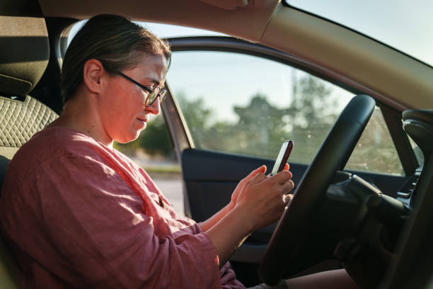istock Woman using mobile phone on driver seat in the car. 2171094700