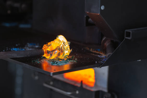istock Molten glass fusing with colorful fragments on a blowing pipe 2171095879