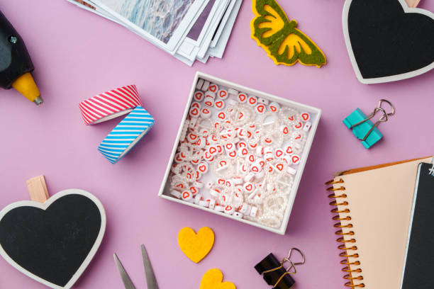istock Crafting supplies arranged on a pink background, including glue gun, scissors, and decorative items for DIY projects 2171099687