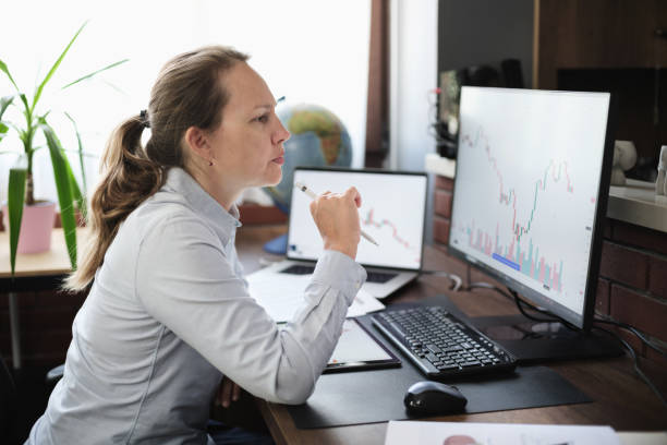 istock Business woman working in the office on stock market exchange data using desktop computer and digital tablet 2171100123
