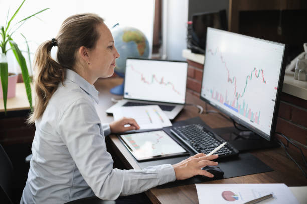 istock Business woman working in the office on stock market exchange data using desktop computer and digital tablet 2171101649