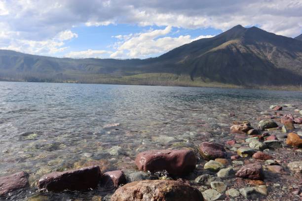 istock Rocky lakeshore with mountain range and clear water. 2171101660